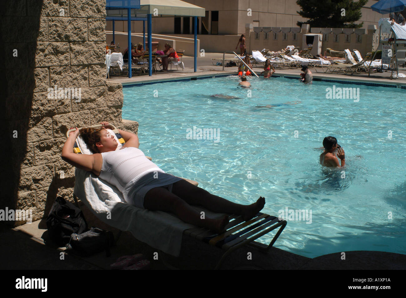 Donna sovrappeso valutazione a prendere il sole su una sedia a sdraio a bordo piscina dell'Hotel Luxor Foto Stock