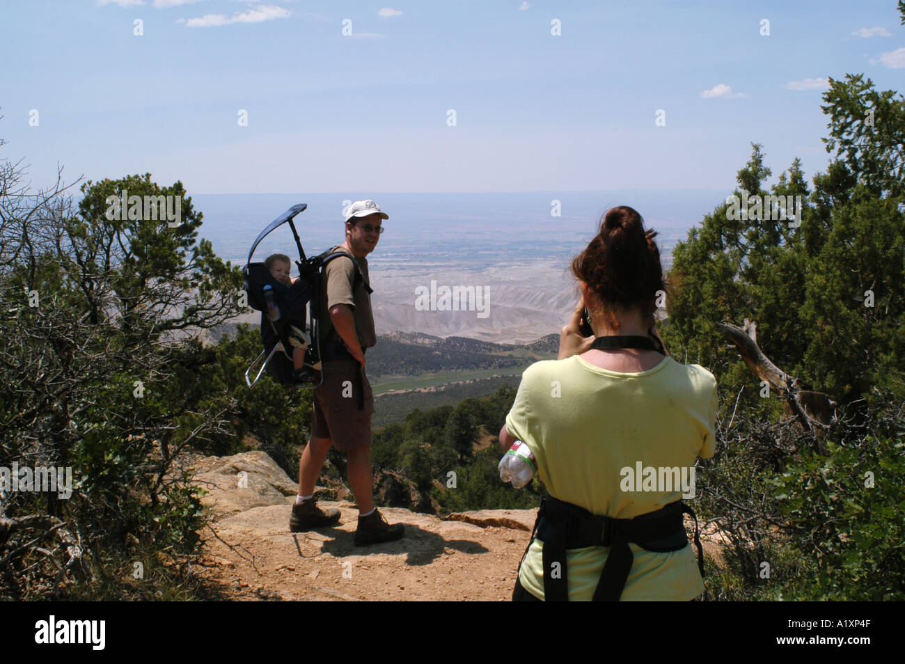 Una donna prende una fotografia di un uomo che porta un bambino. Colorado USA Foto Stock