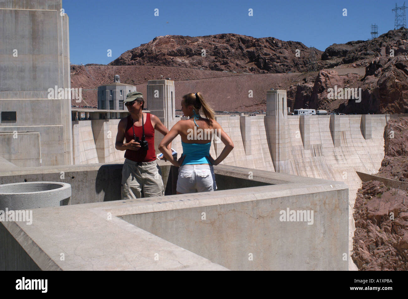 Due turisti su 726 piedi di parete in calcestruzzo dello spanning del Black Canyon del Colorado come la più grande diga dell'emisfero occidentale la Diga di Hoover è diventato il Nevada s più popolare gioco d'azzardo non attrazione turistica la Diga di Hoover è stata costruita nel 1935 per controllare la violenta del Fiume Colorado e fornire acqua ed energia idroelettrica che ha portato all' allargamento e la continua crescita di Las Vegas vicino a Boulder City Foto Stock