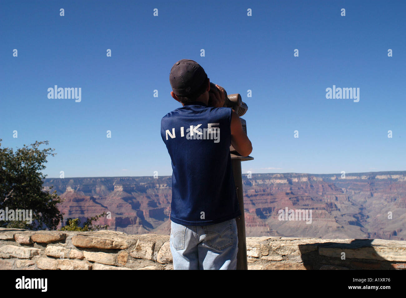 Un ragazzo in una maglietta Nike opinioni il Grand Canyon attraverso un telescopio Bright Angel Lodge South Rim Grand Canyon Foto Stock