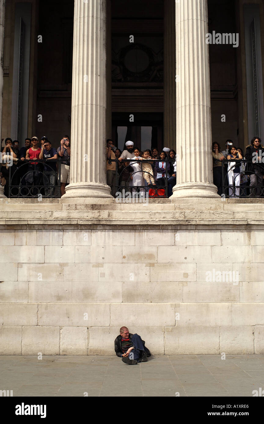 Un uomo rilassante sotto il sole sotto le colonne del National Portrait Gallery Trafalgar Square Foto Stock