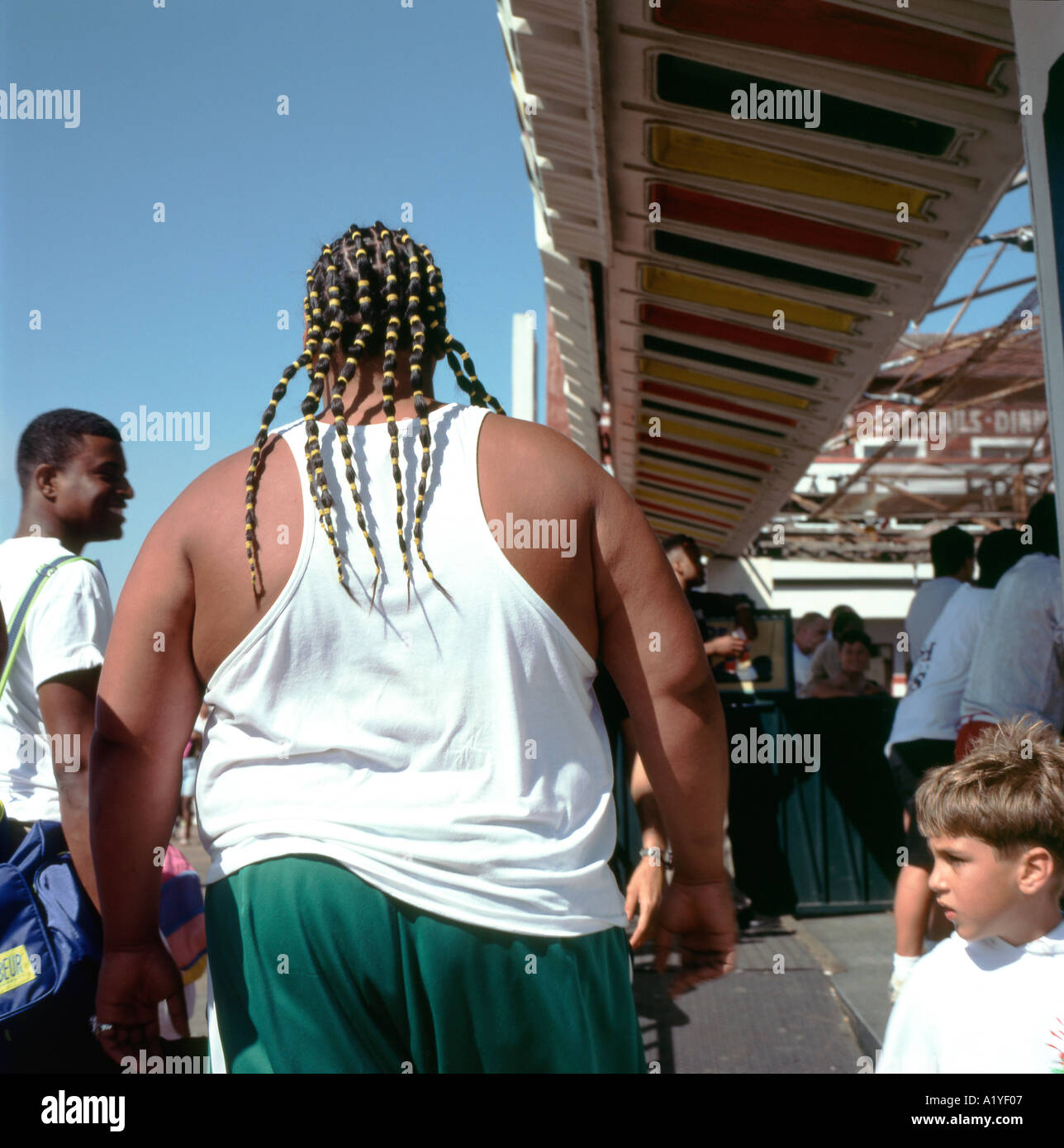 Nero grande uomo obesi da dietro con capelli intrecciati sul molo di Santa Monica a Los Angeles California US KATHY DEWITT Foto Stock