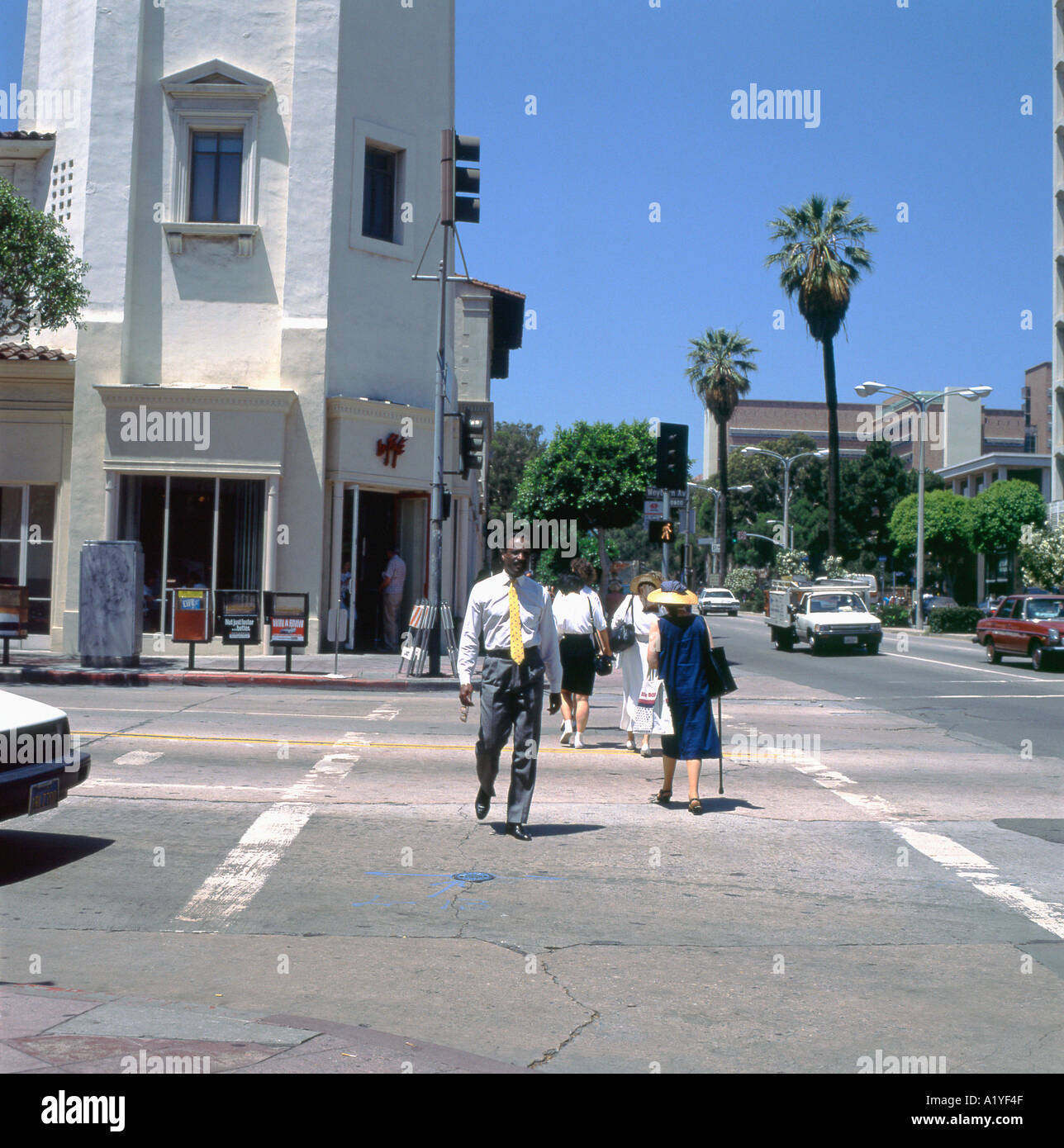 Uomo d'affari nero che attraversa la strada a Westwood Village LA Los Angeles California America USA nel 1989 1990 KATHY DEWITT Foto Stock