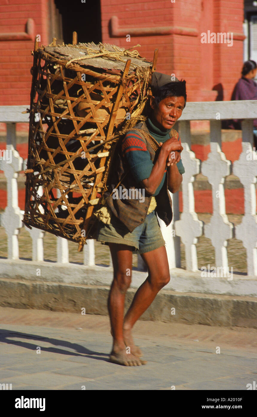 Uomo che lavora come un facchino che porta un cesto di vimini vicino Durbar di Kathmandu in Nepal Asia J Green Foto Stock