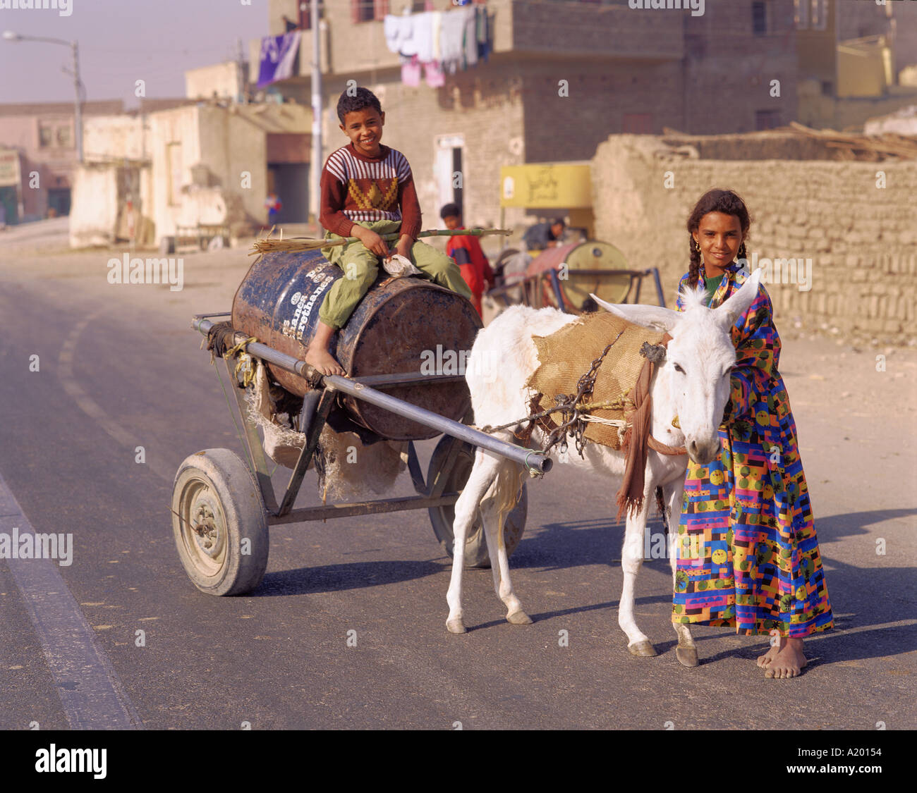 Ritratto di bambini recupero waterl su un asino carrello Tebe Luxor Egitto Africa G R Richardson Foto Stock