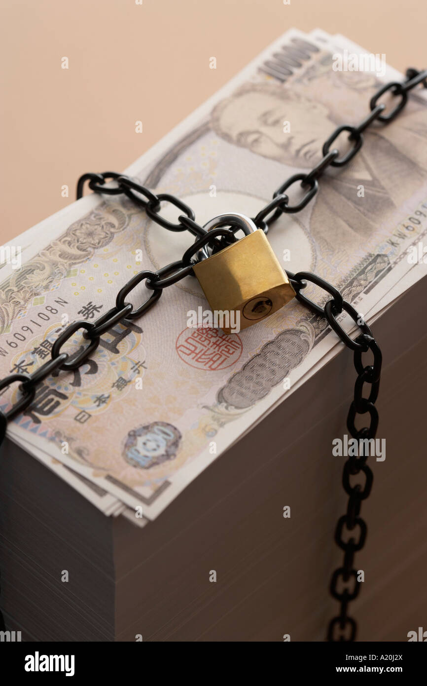 Pila di banconote fissato mediante un lucchetto e la catena Foto Stock