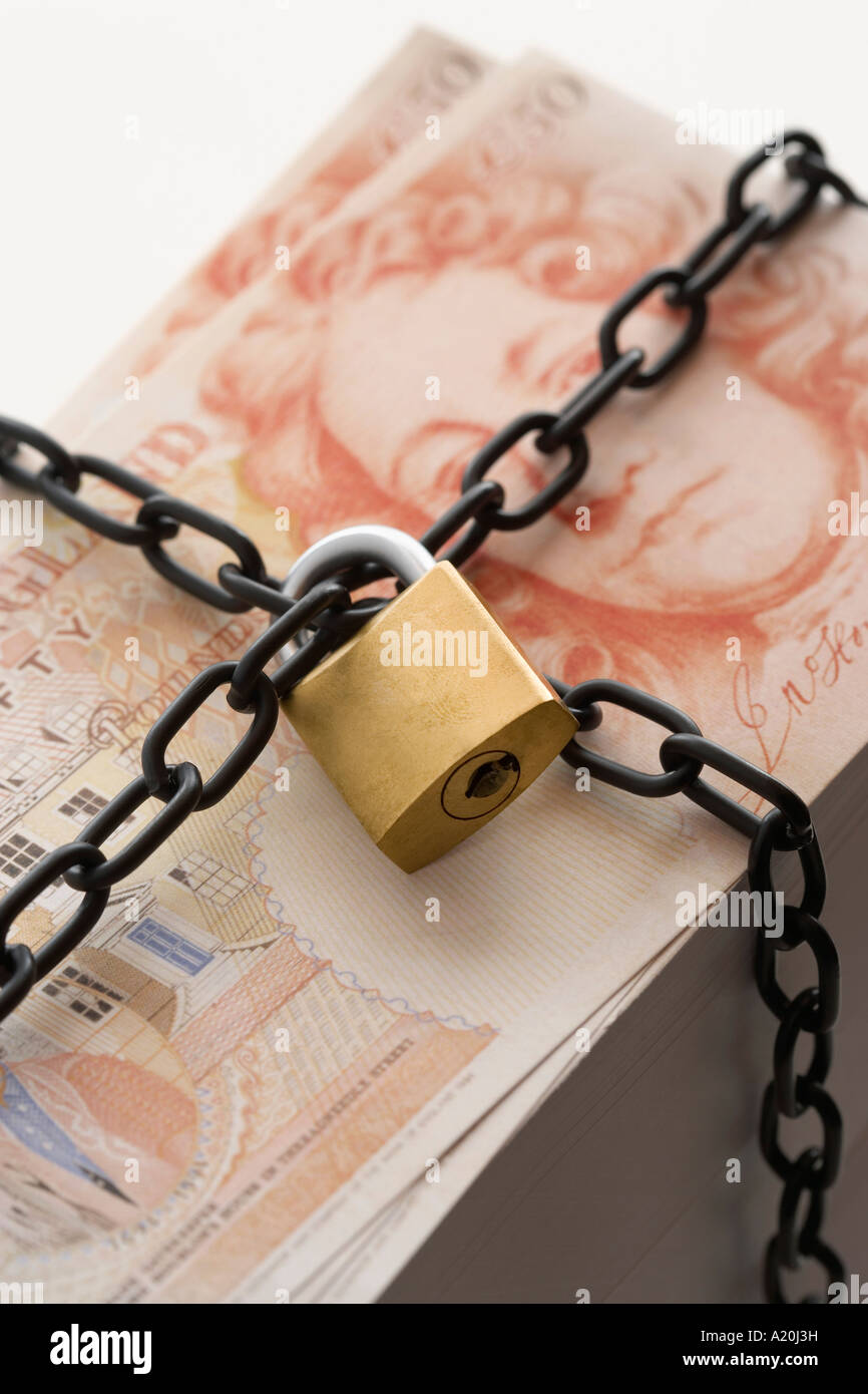 Pila di cinquanta pound note fissato mediante un lucchetto e la catena Foto Stock