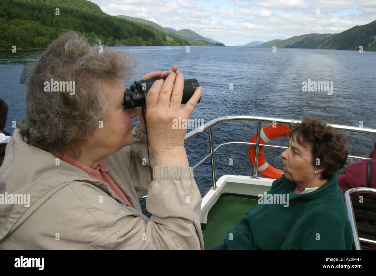 Donna seduta su un giorno di viaggio di piacere cruiser su Loch Ness sperando di vedere Nessie il mostro di Loch Ness, Scozia Foto Stock