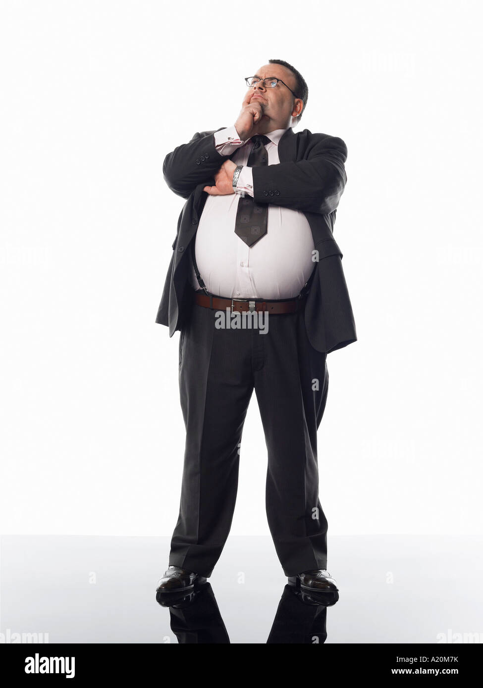 Imprenditore in sovrappeso in piedi con la mano sul mento Foto Stock