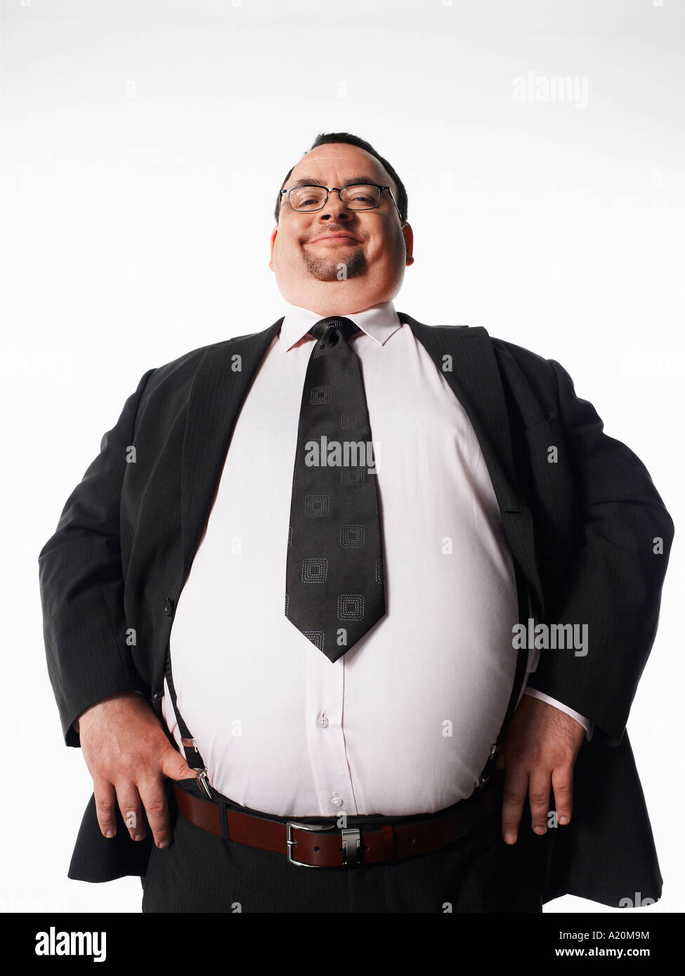 Il sovrappeso sorridente imprenditore con le mani sui fianchi Foto Stock