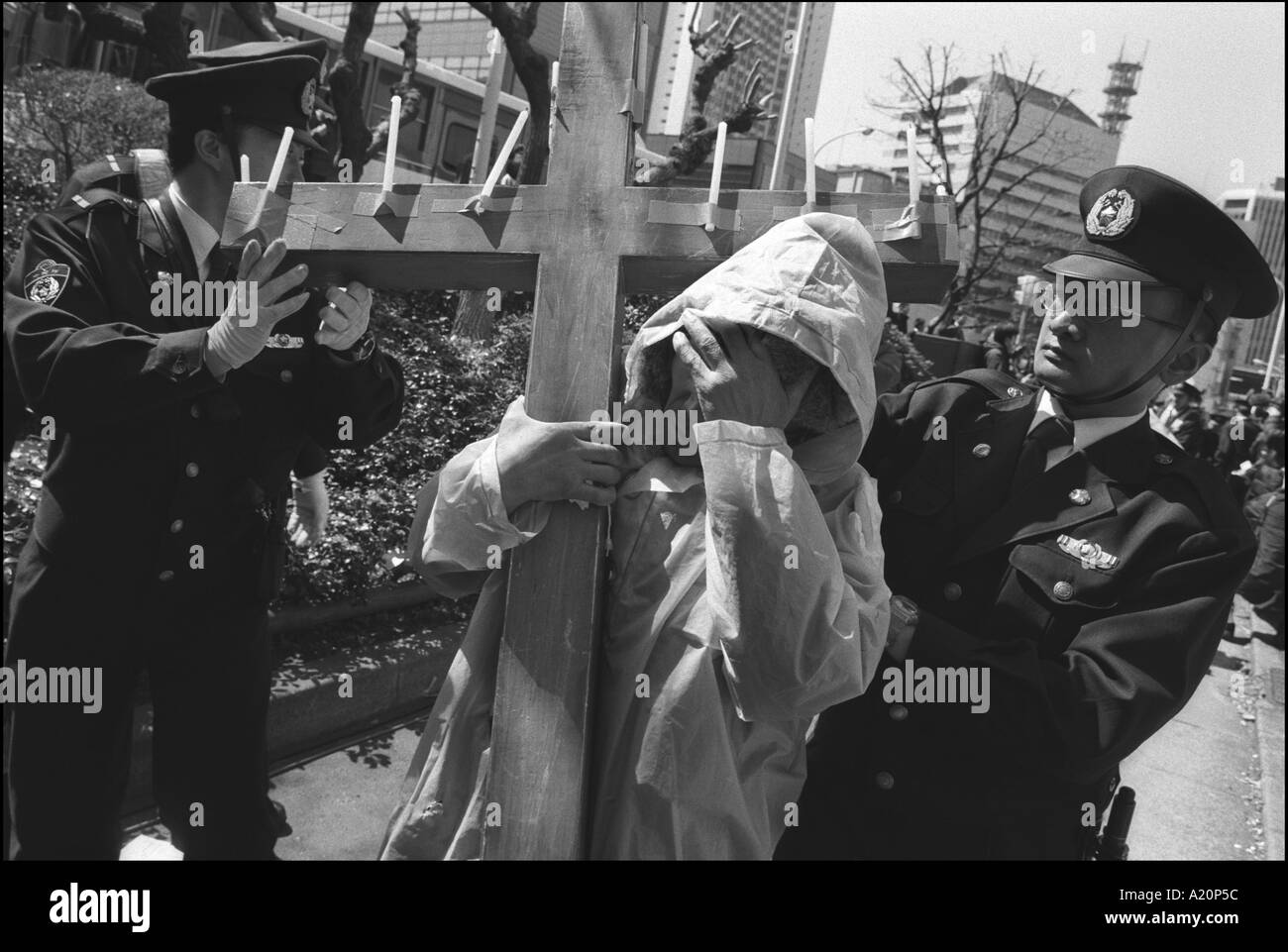 Poliziotti di rimuovere un protestor e il suo crocifisso in legno che lui ci era stato portante durante l'anti-war demo, Tokyo, Giappone Foto Stock