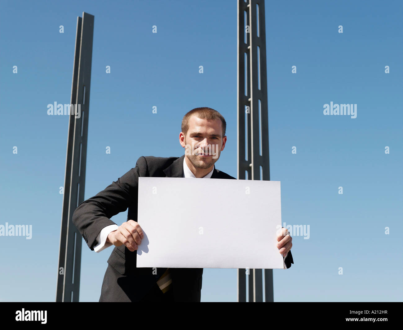 Giovane uomo con foglio di carta da pilastri di calcestruzzo Foto Stock