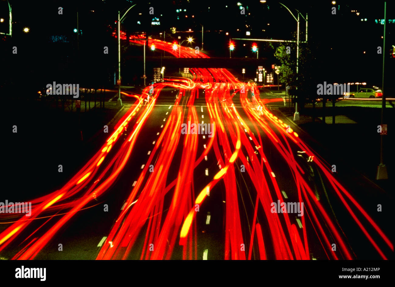 Luci sfocate di traffico che viaggia attraverso un centro di intersezione di notte Foto Stock