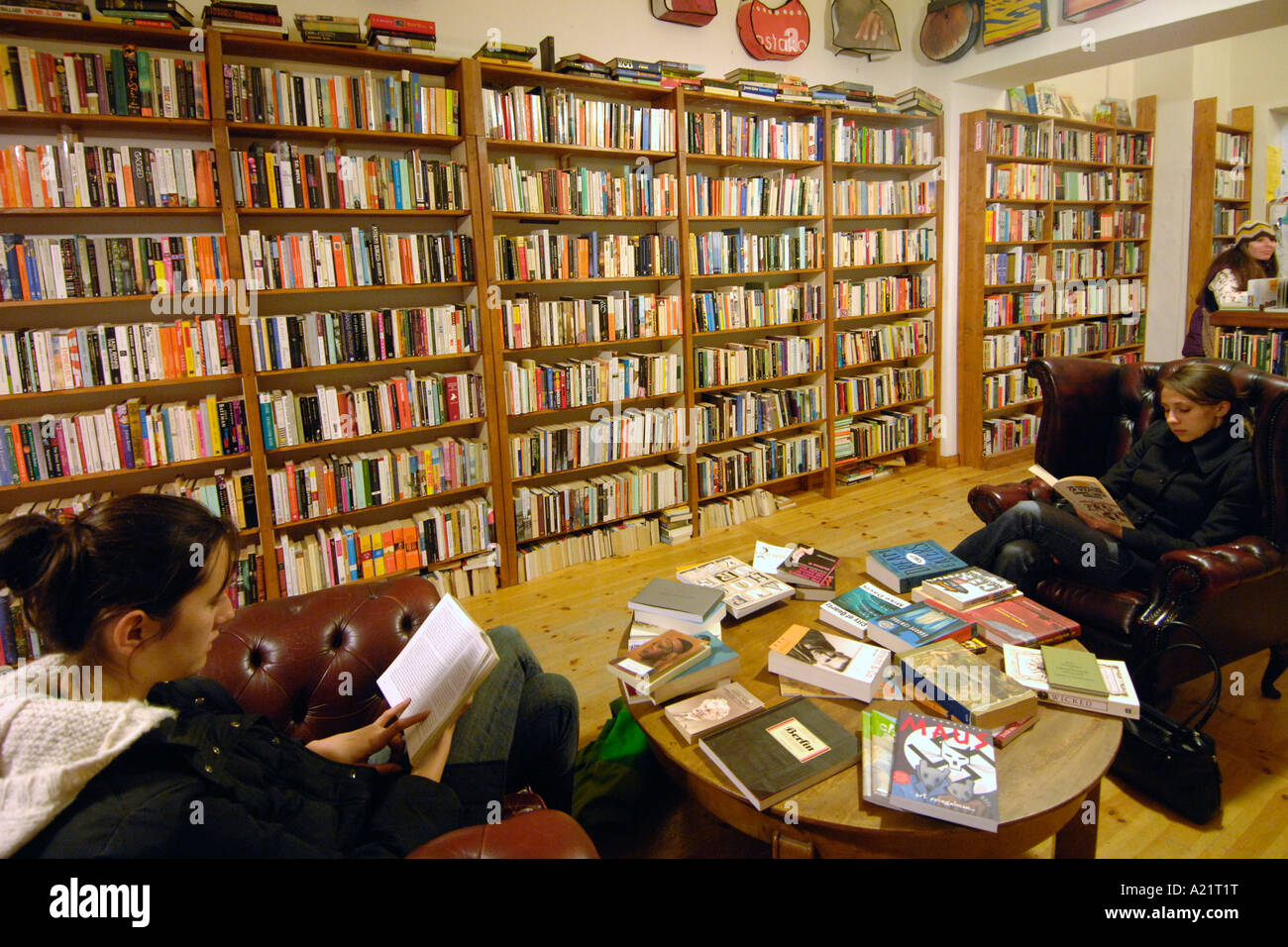 Due ragazze la lettura all'interno della St Georges English Bookshop di Berlino Est. Foto Stock