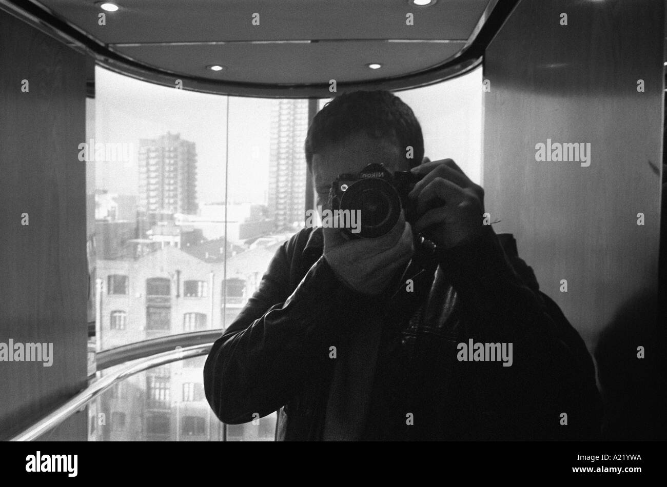 Un fotografo di scattare una foto di se stesso con una telecamera in specchio Foto Stock