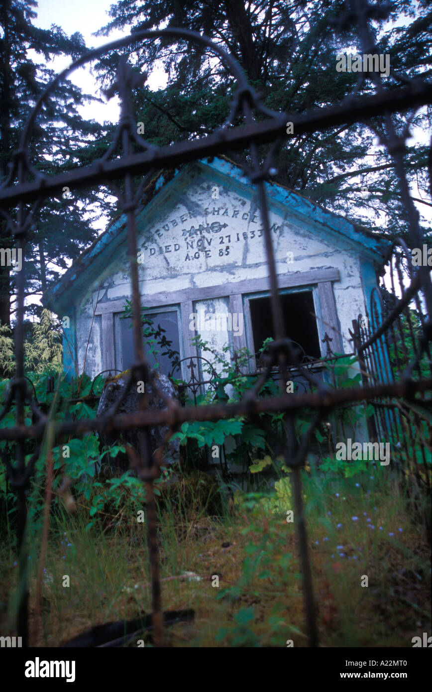 Cripta Masoleum e arrugginita recinzione in ferro in un cimitero in Alaska Foto Stock