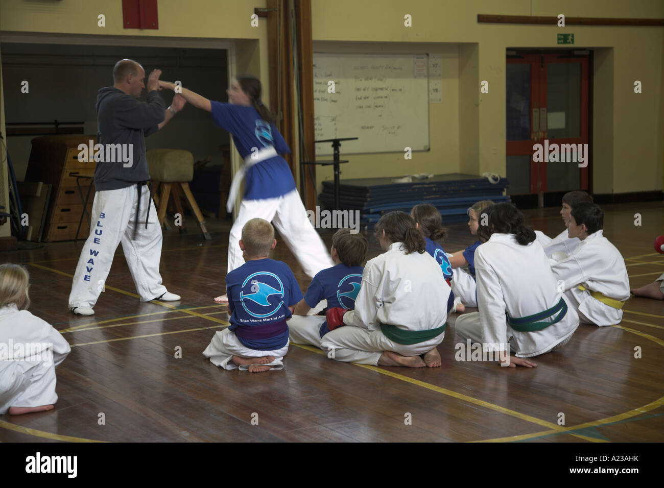 Istruttore con i bambini di differenti età al karate club in palestra scuola hall REGNO UNITO Foto Stock