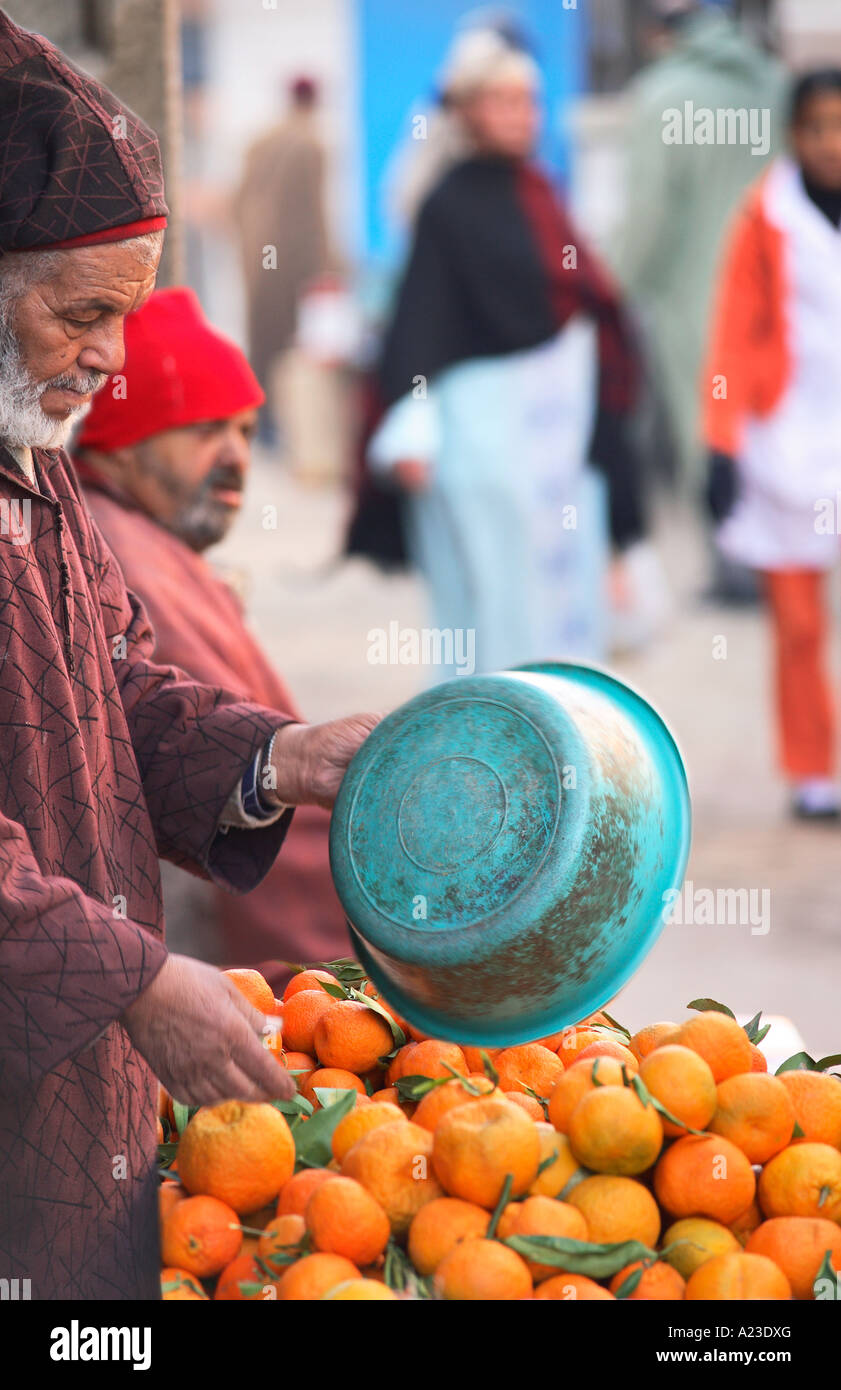 Una scena di strada a marrakech marocco che mostra un uomo vecchio vendita di arance indossando panni tradizionale. Foto Stock