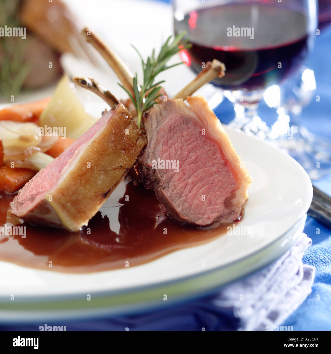 Carré di agnello con salsa al vino rosso due bistecche con salsa di verdure round guarnito con rosmarino Foto Stock