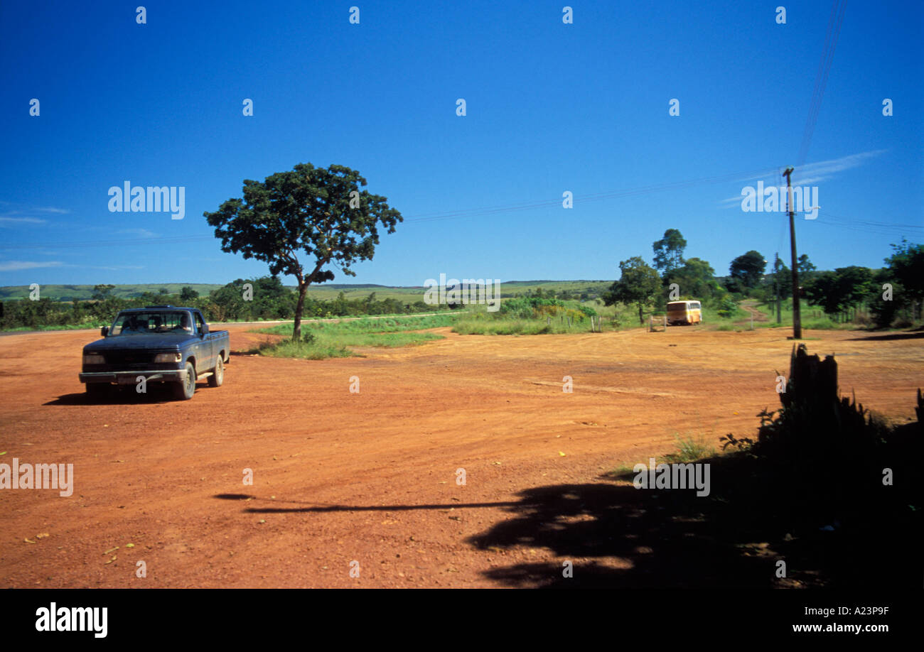 Terra rossa strada con carrello e un albero in Stato di Goias Brasile Foto Stock