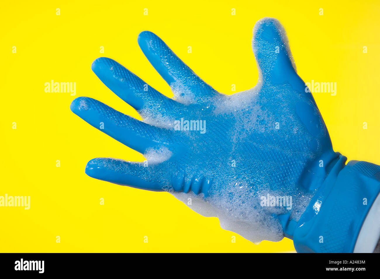 Parte in gomma blu guanto con sapone liquido per lavare i guanti protettivi con detersivo liquido bolle Foto Stock