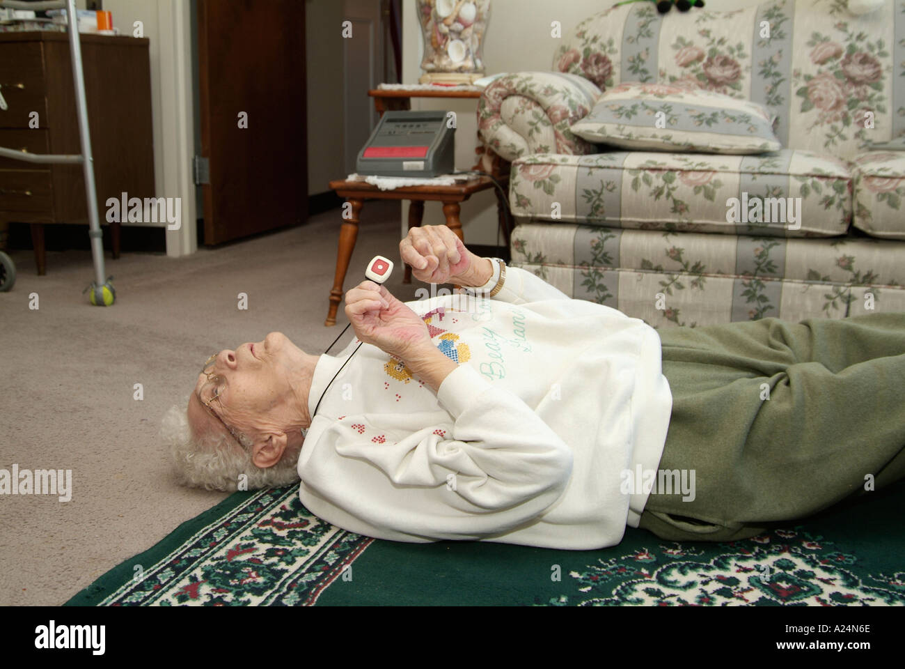 Femmina Senior utilizza un medical alert sistema di allarme per la chiamata di emergenza per aiutare dopo la caduta Foto Stock