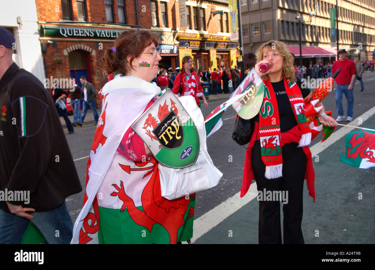 Il Galles rugby fan con il gallese drago rosso di bandiere e sciarpe sulla strada di Cardiff South Wales UK Foto Stock