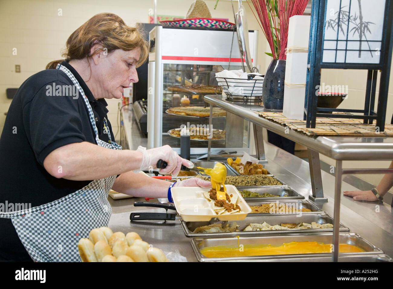 Lansing Michigan un lavoratore serve il pranzo nella caffetteria a Waverly Middle School Foto Stock
