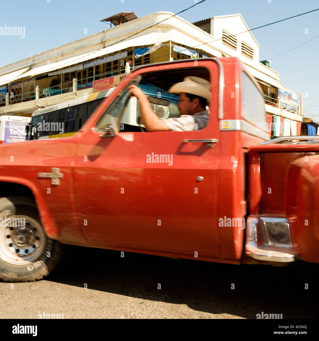 Uomo messicano indossando cowboy aziona un pick up truck veloce a circa un angolo Foto Stock