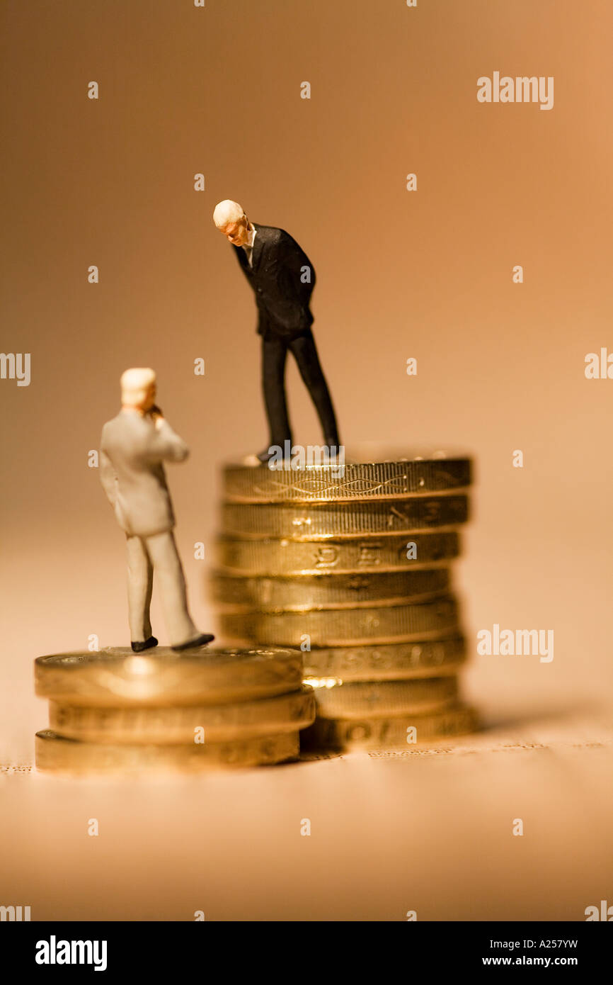 Gli imprenditori in miniatura in piedi sulle monete sul quotidiano finanziario Foto Stock