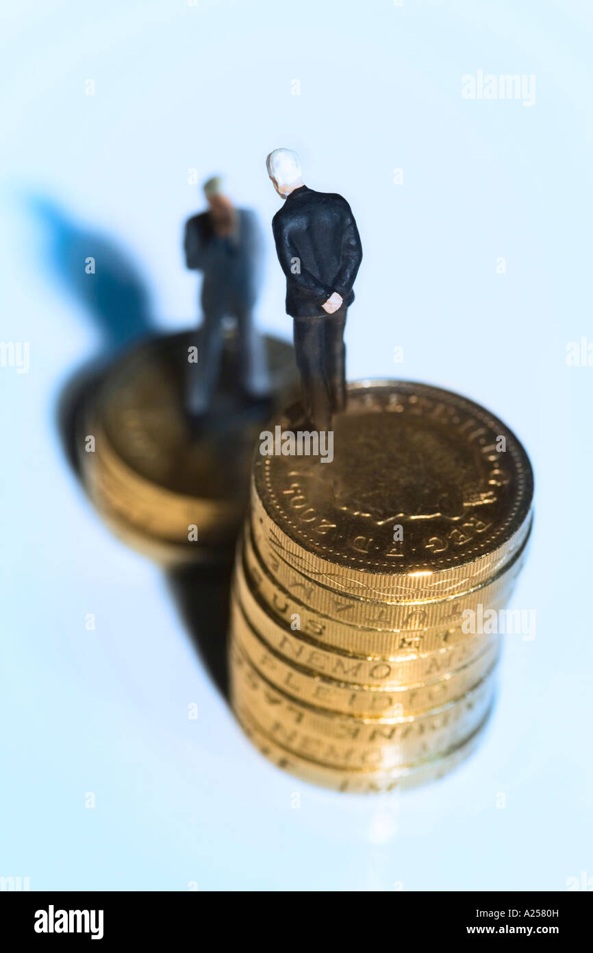 Gli imprenditori in miniatura in piedi sulle monete Foto Stock