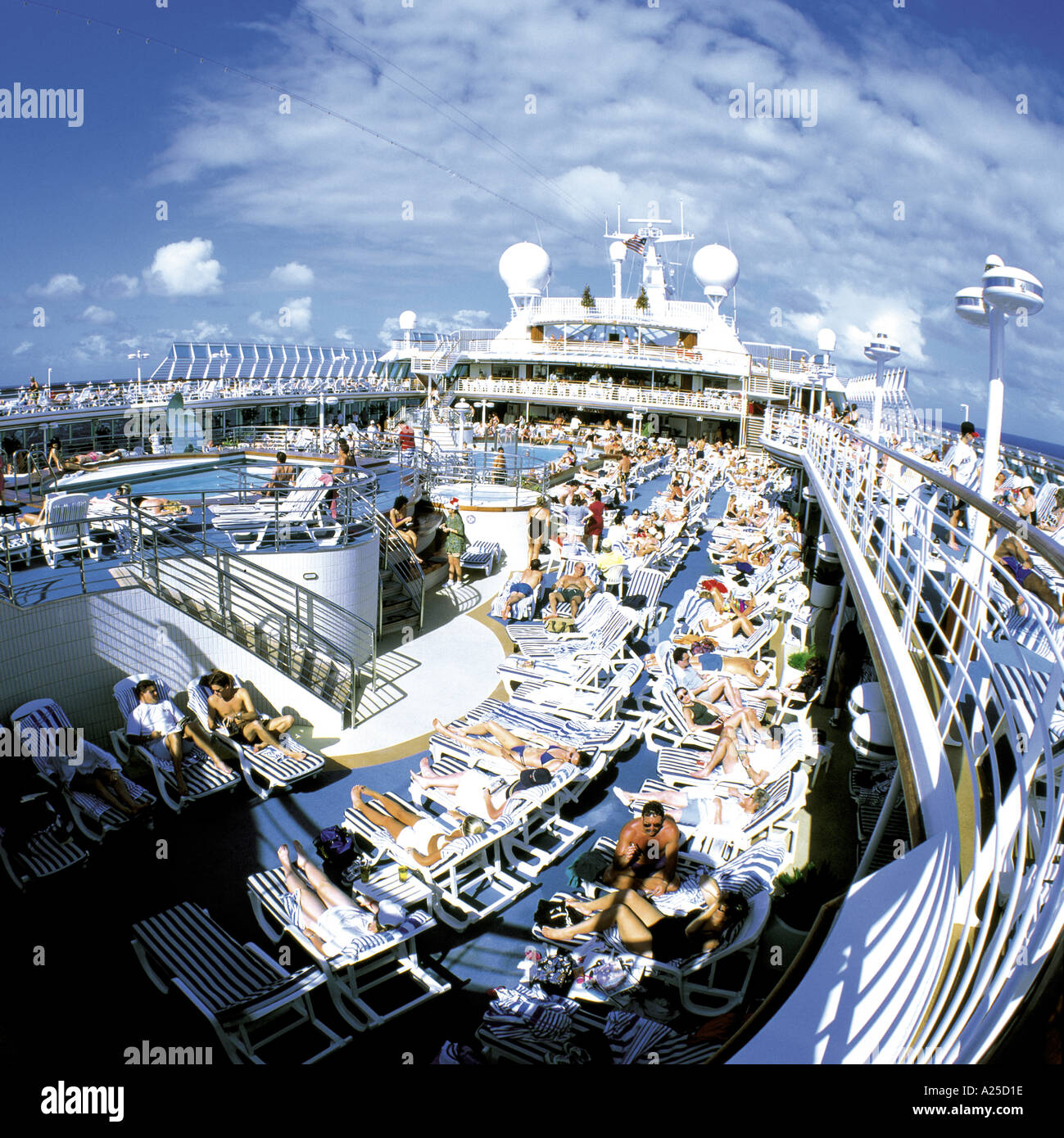 I PASSEGGERI SU rilassanti sedie a sdraio sul ponte della crociera di lusso Foto Stock
