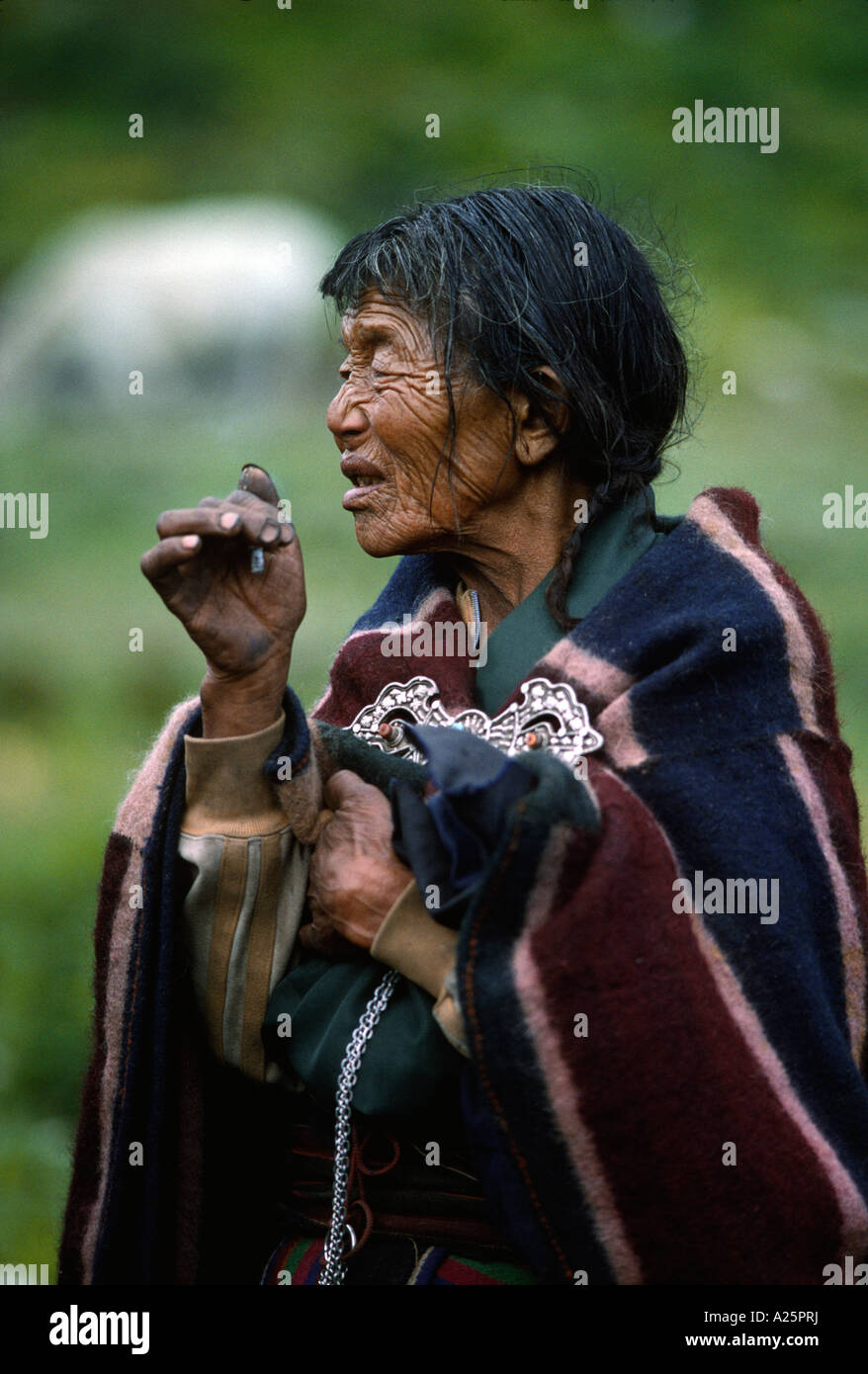 Vecchia donna fumatori cigarrette in DOLPO copertura in corrispondenza di un tibetano buddista Festival in DO TARAP VALLEY QUARTIERE DOLPO NEPAL Foto Stock
