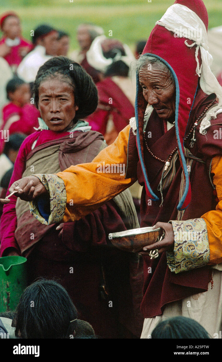 Un monaco benedice i credenti da un essere umano SCULL CUP presso un tibetano buddista Festival in DO TARAP VALLEY QUARTIERE DOLPO NEPAL Foto Stock
