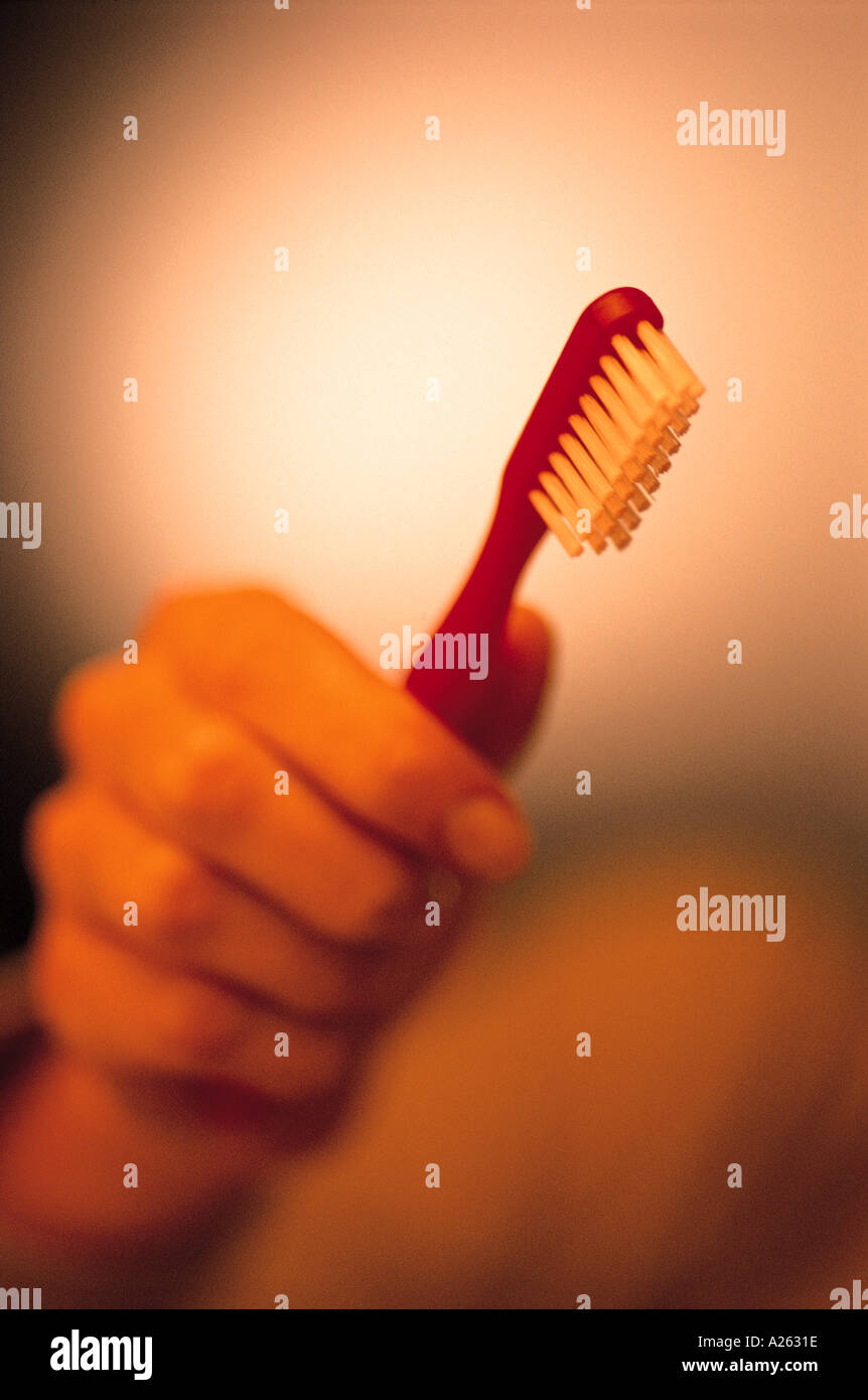 Mano AZIENDA RED SPAZZOLINO DA DENTI Foto Stock