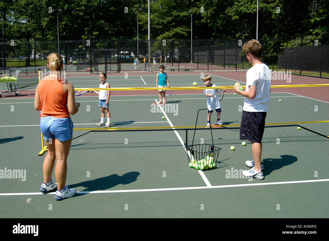 Lezioni di tennis sono forniti da un comune locale per aiutare i bambini a imparare il gioco di tennis Foto Stock