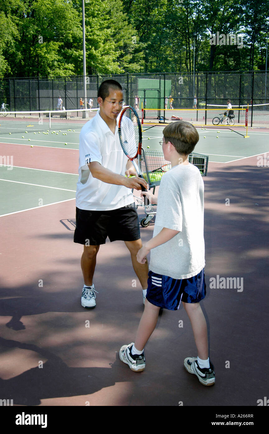 Lezioni di tennis sono forniti da un comune locale per aiutare i bambini a imparare il gioco di tennis Foto Stock