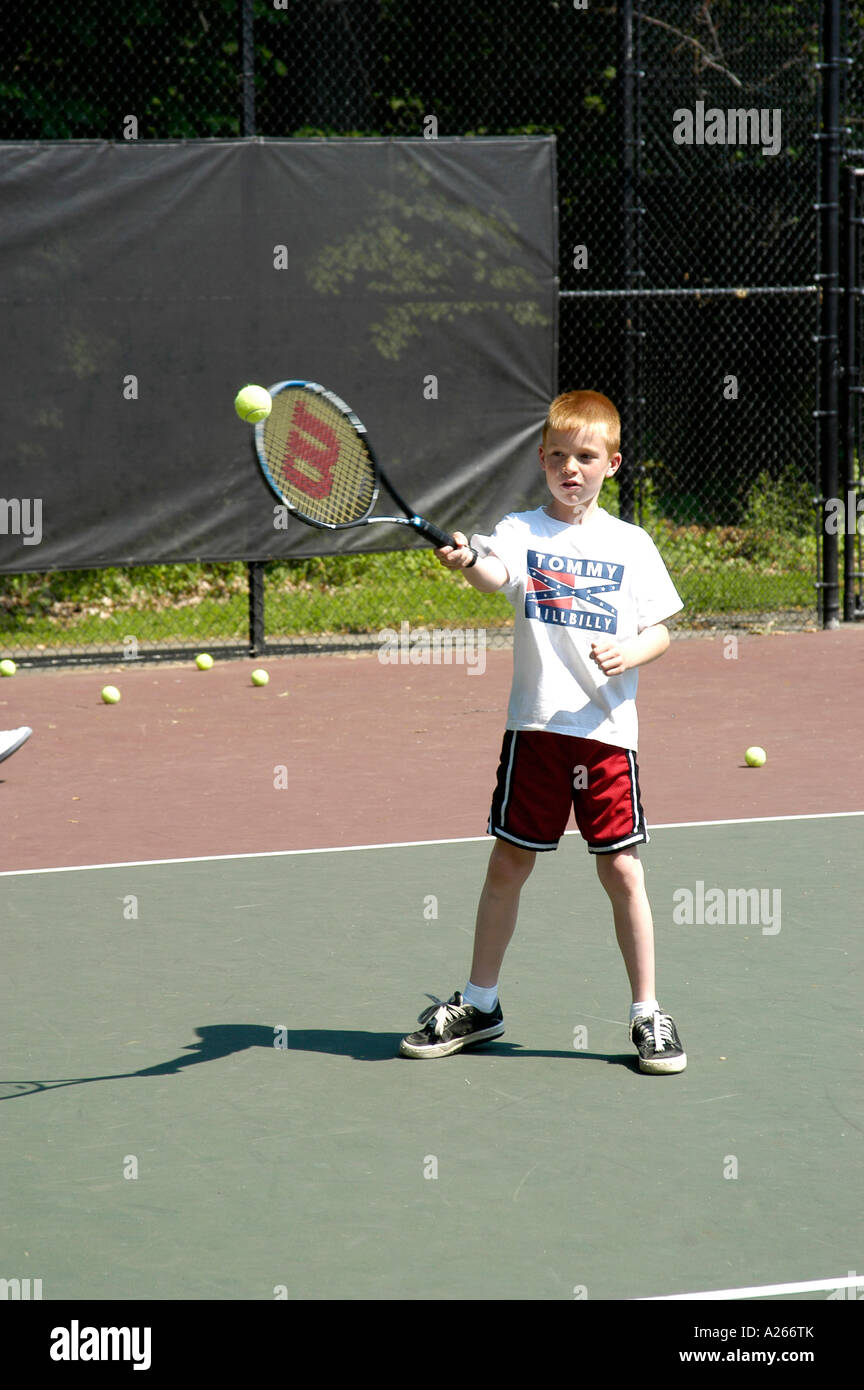 Lezioni di tennis sono forniti da un comune locale per aiutare i bambini a imparare il gioco di tennis Foto Stock