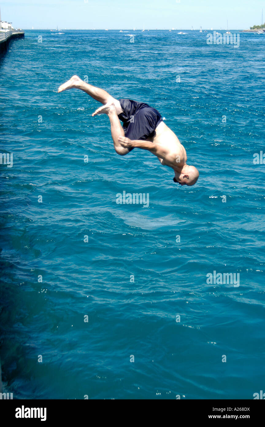 Teenage immersioni maschio testa prima in acqua in un giorno caldo Foto Stock