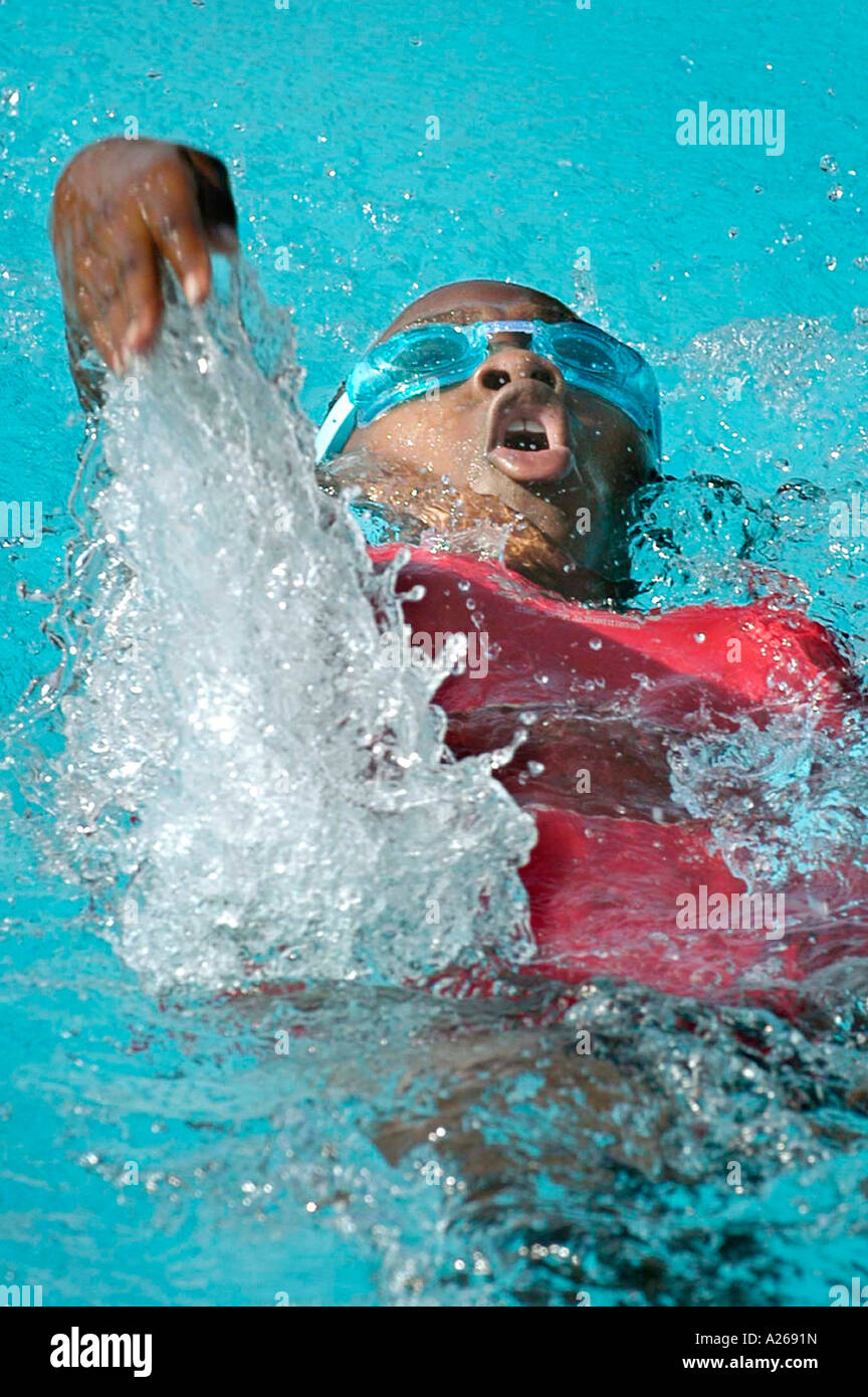 Bambino nero afroamericano che fa il backstroke in una corsa di nuoto Foto Stock