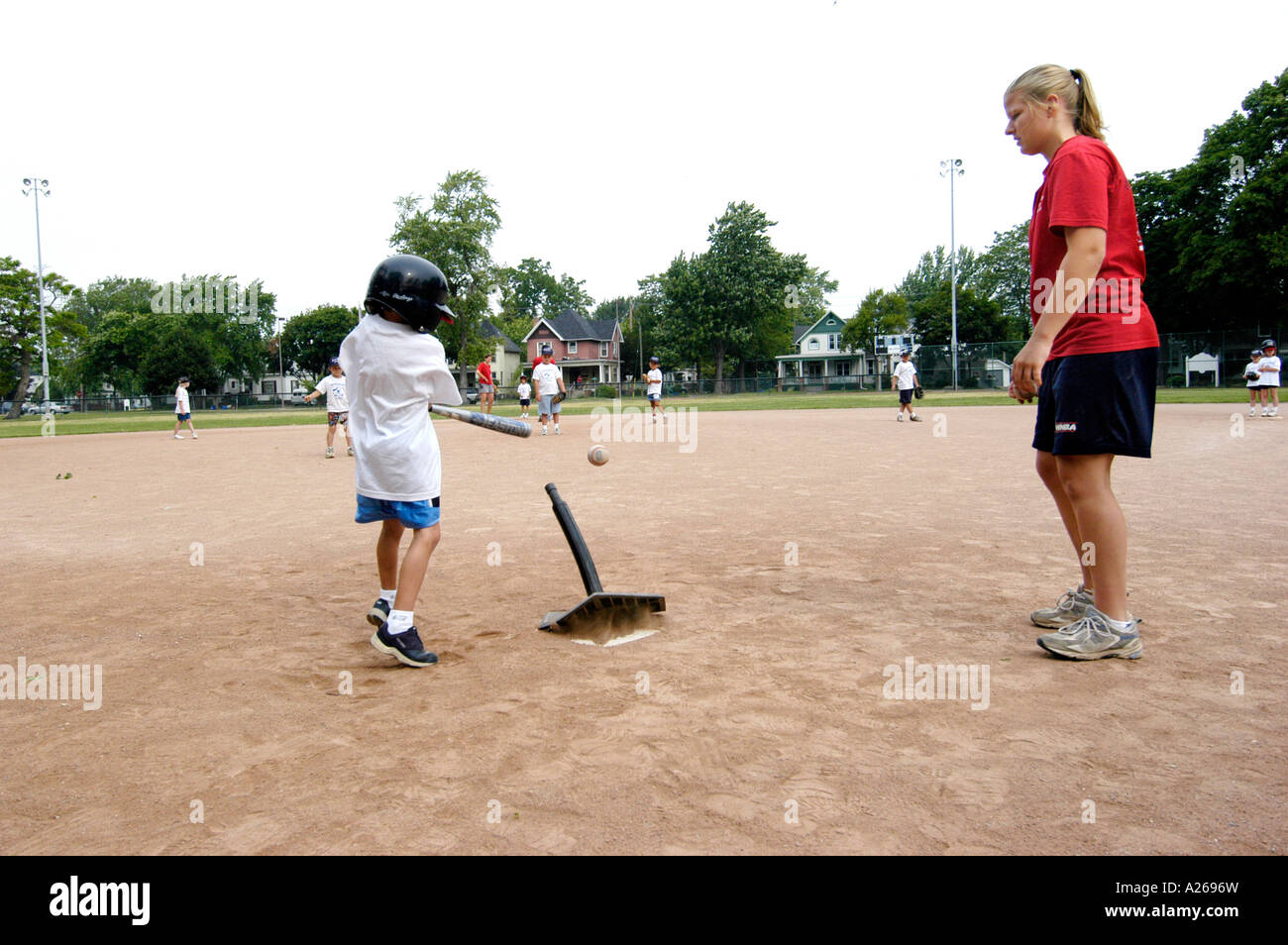 Da 5 a 7 anni i bambini e le bambine prese lezioni di baseball da essere introdotti a sfera T little League Foto Stock