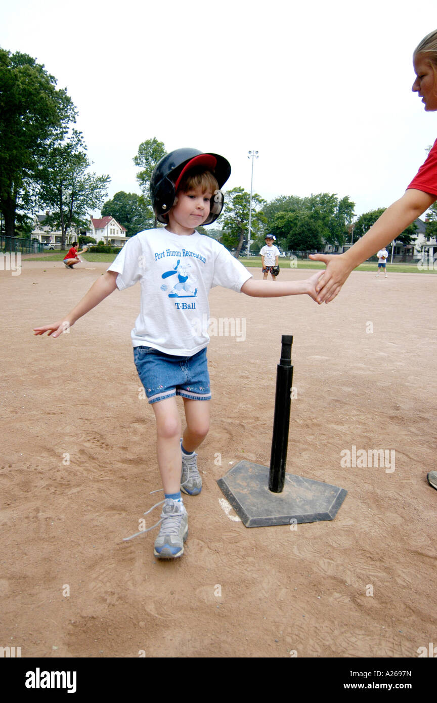 Da 5 a 7 anni i bambini e le bambine prese lezioni di baseball da essere introdotti a sfera T little League Foto Stock