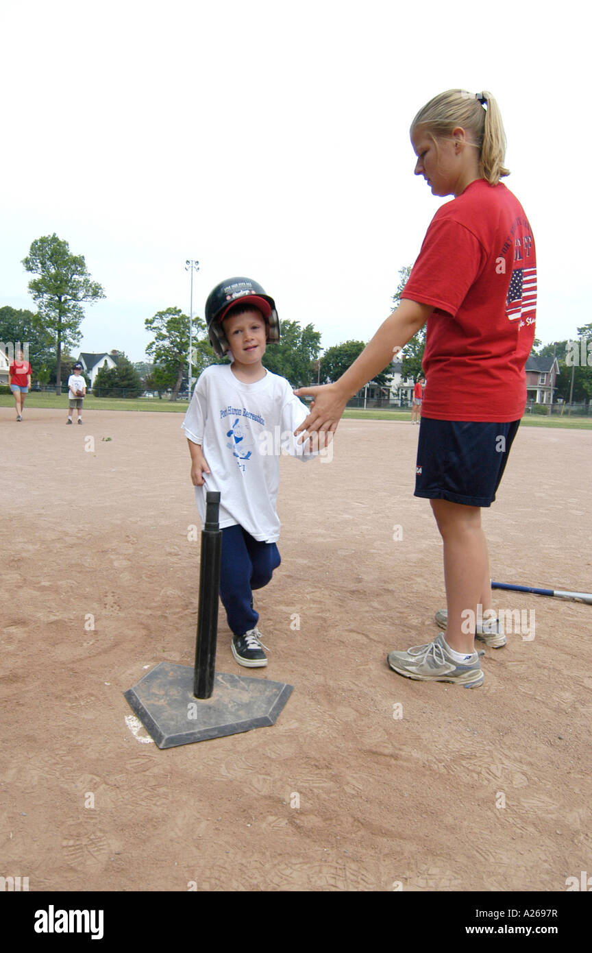 Da 5 a 7 anni i bambini e le bambine prese lezioni di baseball da essere introdotti a sfera T little League Foto Stock