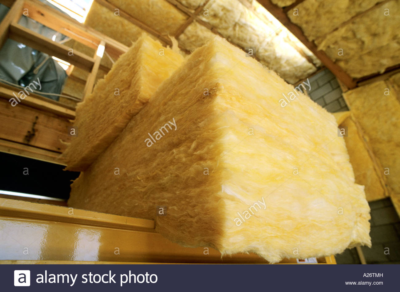 R38 isolamento in fibra di vetro essendo installato nel tetto nel nuovo stile loft home in costruzione Foto Stock