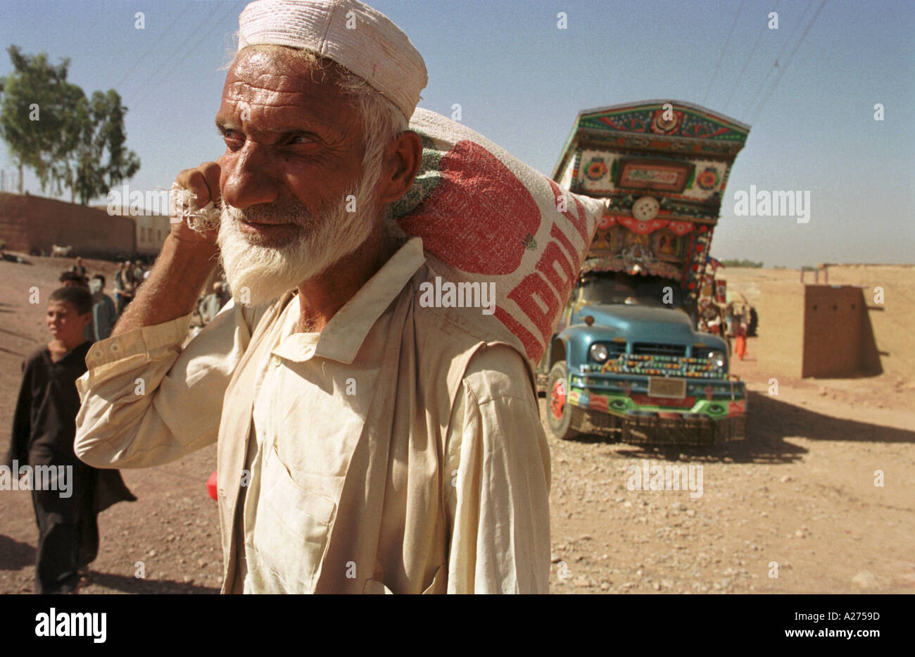 Un profugo afgano si porta a casa il suo cibo per il prossimo mese di Shamshatoo Refugee Camp. Foto Stock