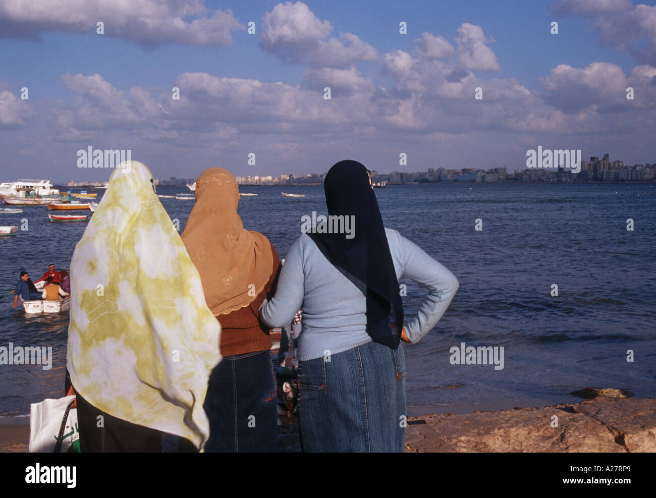 Tre donne con velo guardando il mare di Alessandria d'Egitto Foto Stock