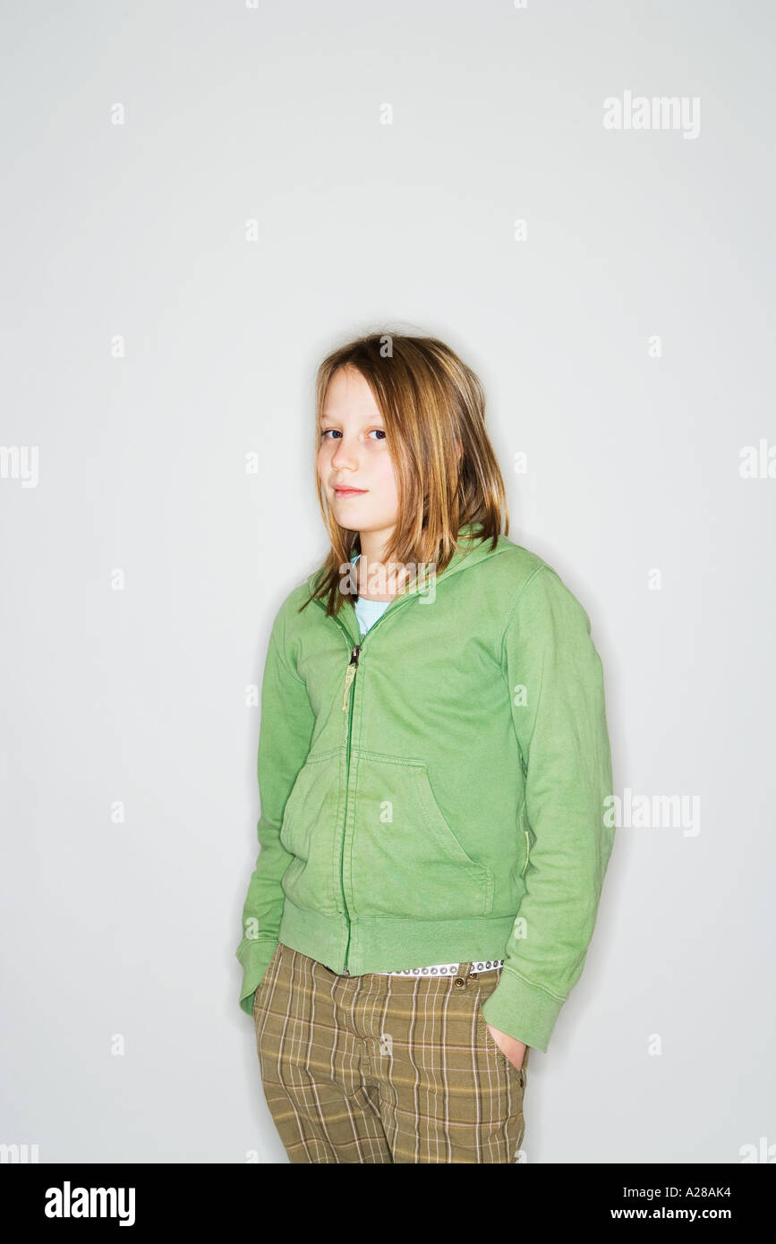 Ritratto di 11 anno vecchia ragazza in piedi con le mani nelle tasche Foto Stock