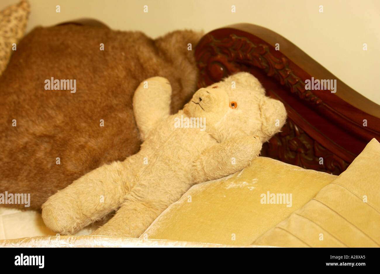 Un orsacchiotto di peluche su un antico letto in legno di quercia Foto Stock
