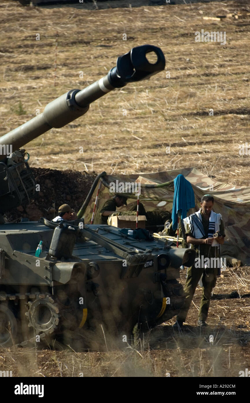Close up del soldato pregando da semoventi pistola in un campo in Israele Foto Stock