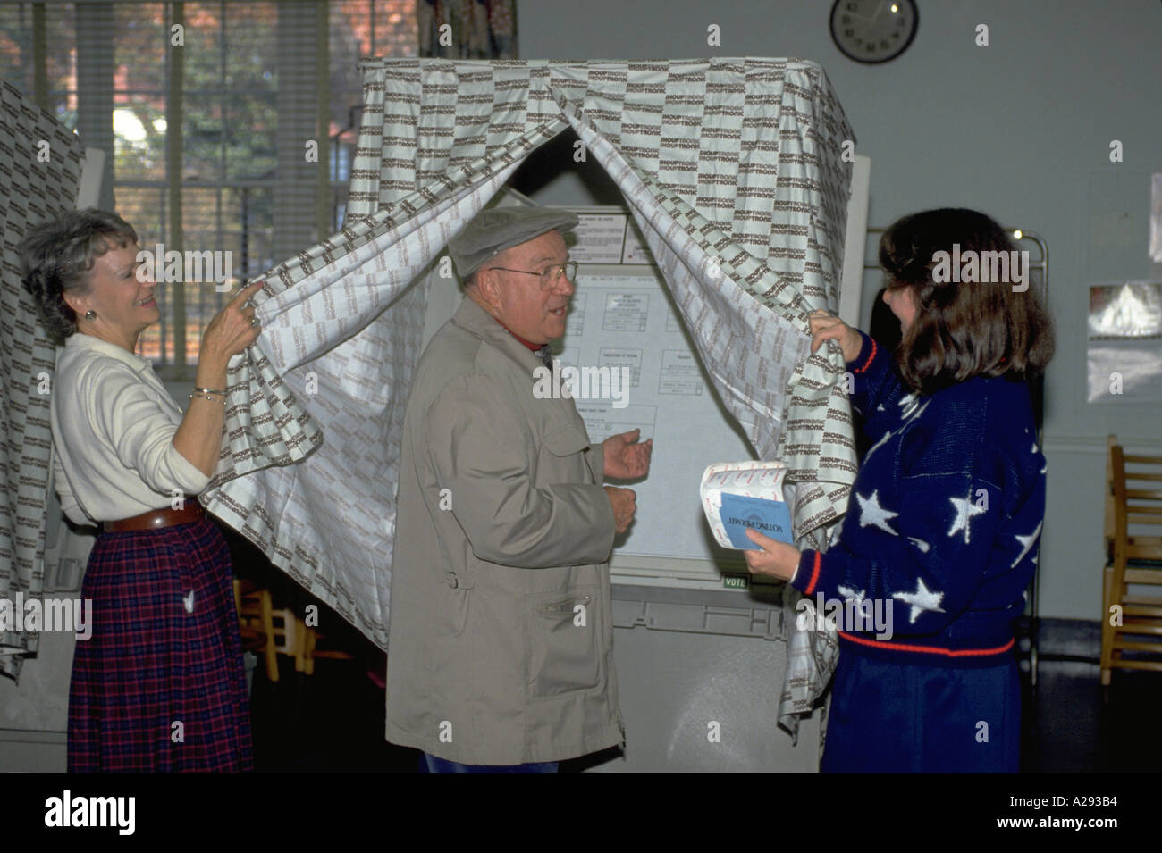 Uomo anziano si appresta a votare come funzionari elettorali lo coadiuvano il giorno delle elezioni in Arlington Virginia Foto Stock